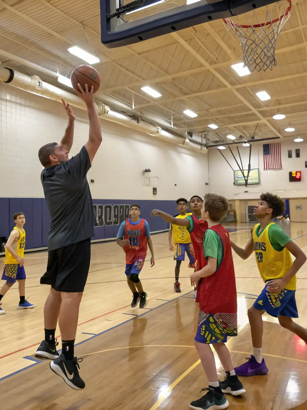 A student leader coaching younger students during a basketball drill, demonstrating leadership skills and mentorship within ASSOCIATION SPORTIVE DU COLLEGE D'ENSEIGNEMENT SECONDAIRE.